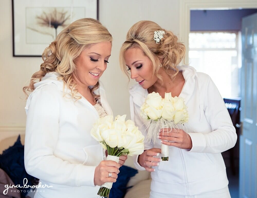 Bride & Bridesmaid look at their white rose bouquets