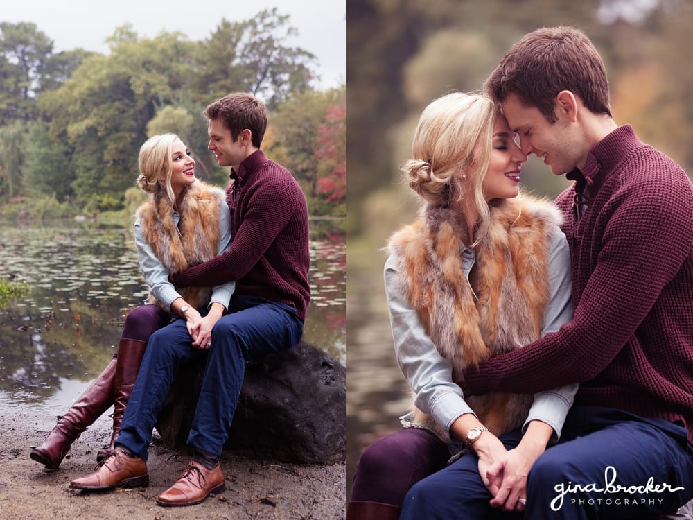 A couple cuddle on a rock during their fall engagement session in newton massachusetts