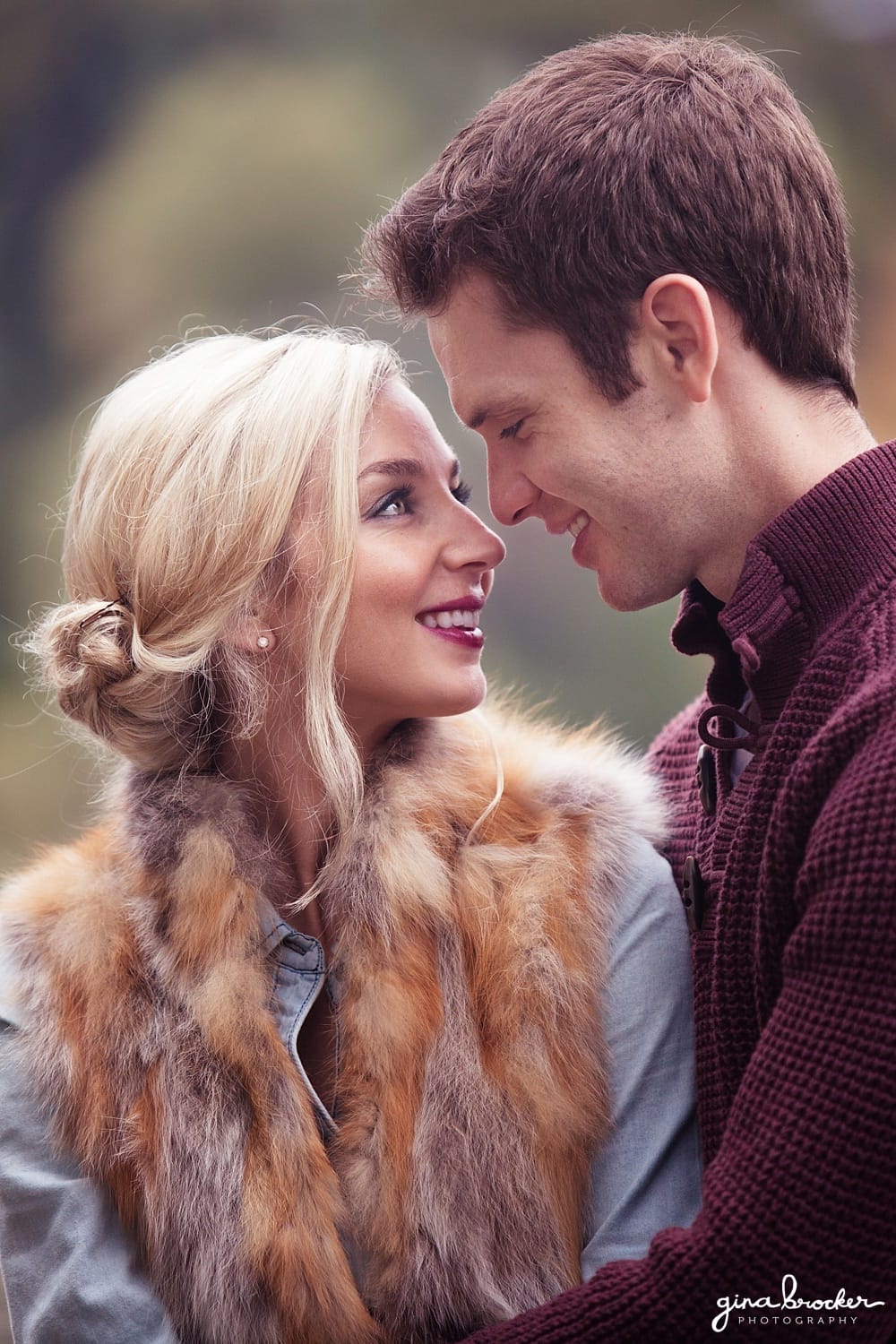 A sweet portrait of a couple looking at one another during their woodsy engagement session in newton massachusetts