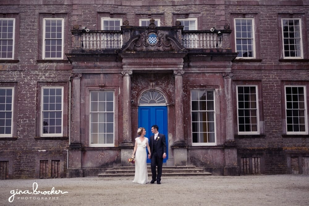 Bride and Groom walk by country house