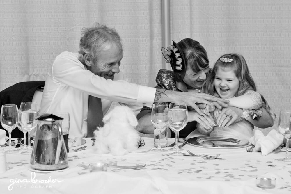 Grandparents laugh with flower girl