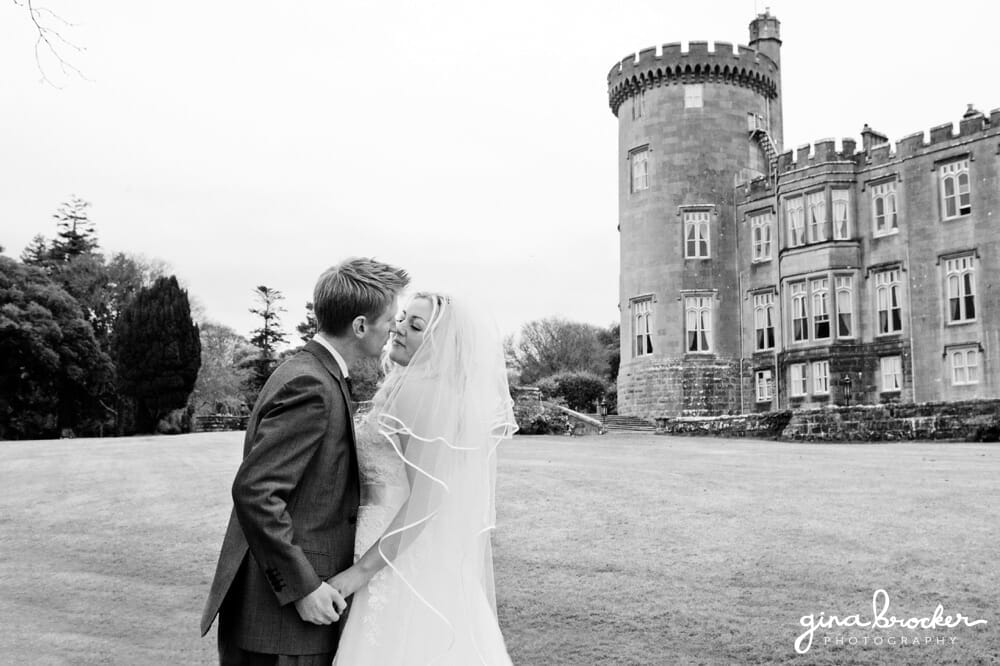 bride and groom kiss beside castle romantic wedding portrait by castle