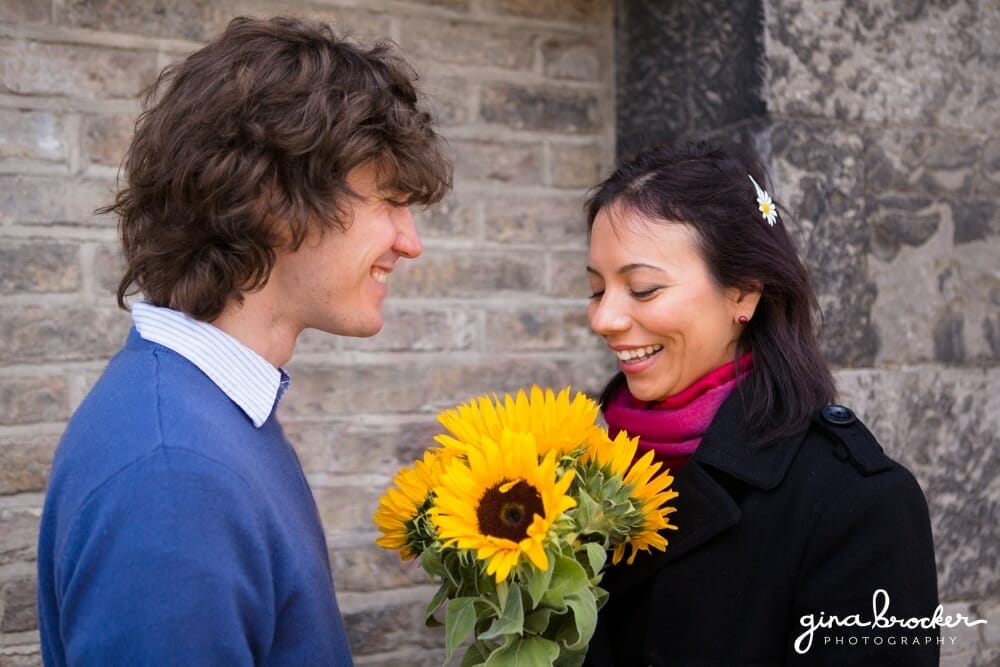 couple with sunflowers A husband gives his wife sunflowers when the meet for their love story session in Boston