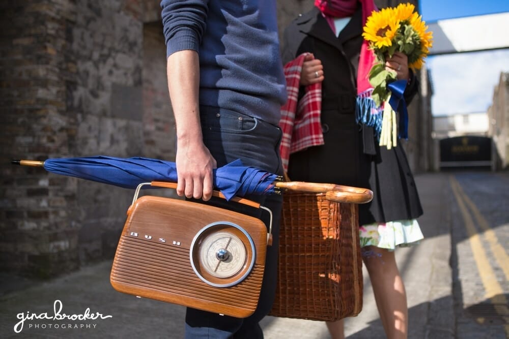 A couple carries their rust picnic supplies to their love story session in Boston