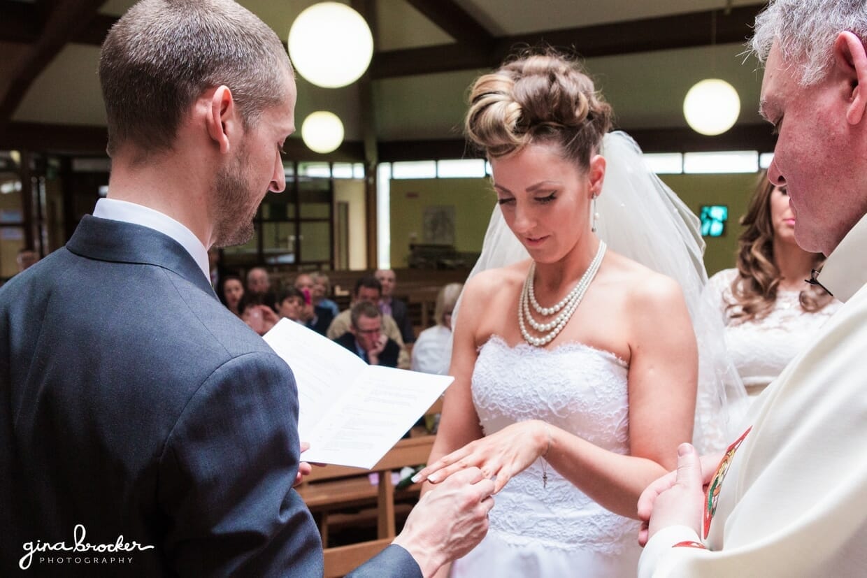 The groom puts the ring on his brides finger