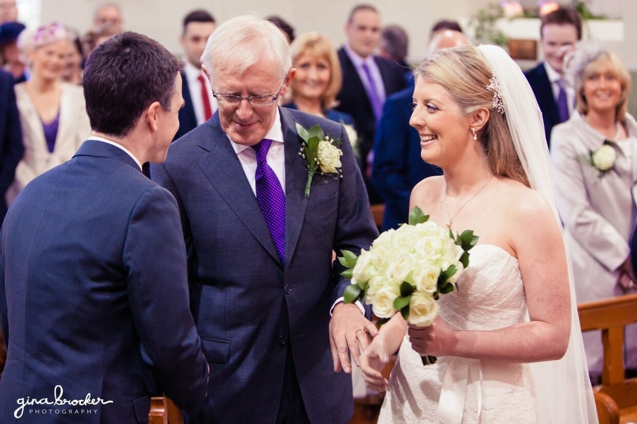 father-giving-daughter-away The groom shakes the father of the brides hand as the meet at the top of aisle during an intimate church wedding