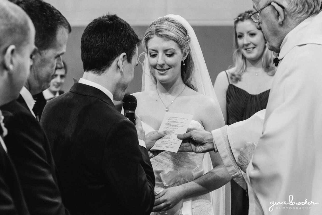 The bride smiles while listening to her new husband's sweet wedding vows at their classic vintage wedding