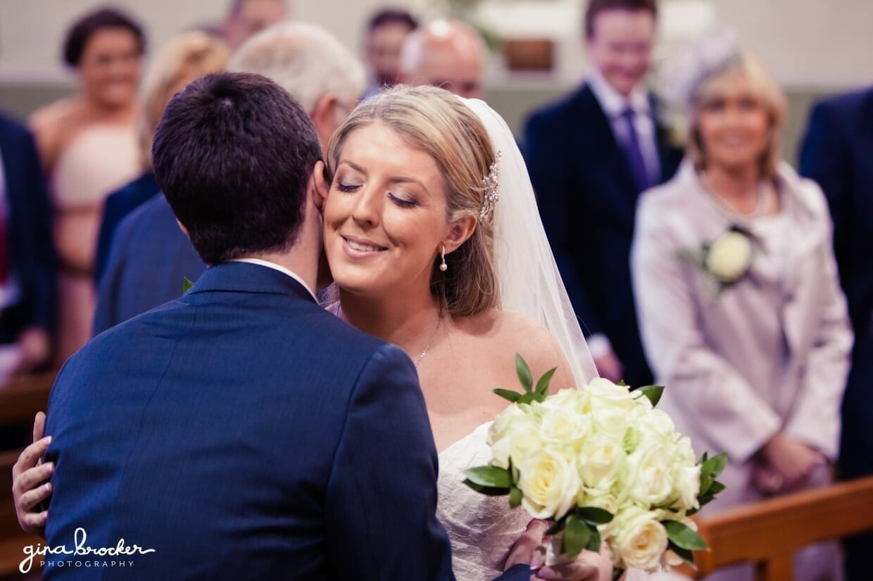 The bride and groom hug after they are pronounced husband and wife at their intimate church wedding