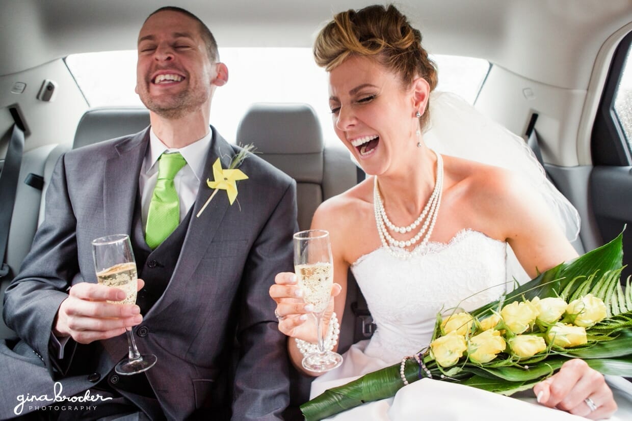 The bride and groom celebrate the day with a glass of champagne in the wedding car