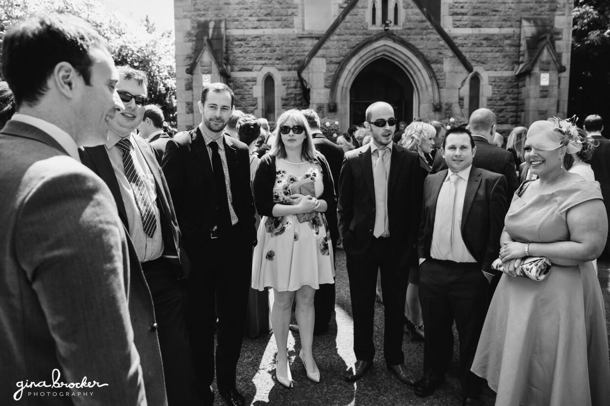 candid.photos.of.wedding.guests A candid photograph of the wedding guests talking after the wedding ceremony in a local church