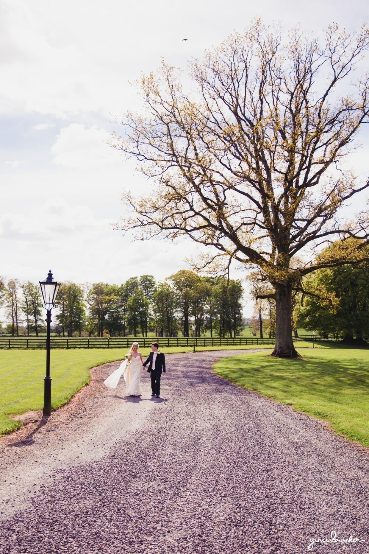 The bride and groom share a romantic walk during their classic vintage wedding