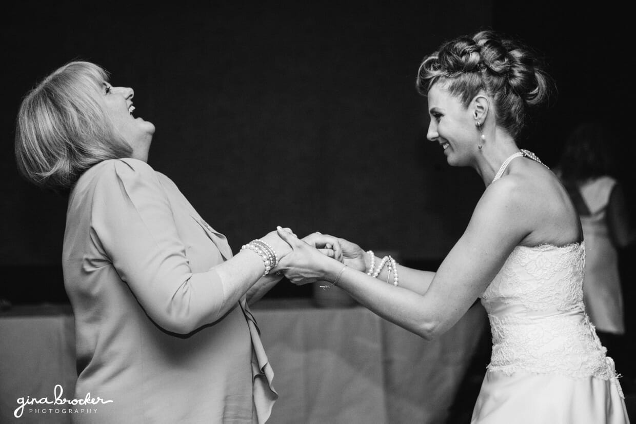 The bride and aunt laugh as they dance at this fun wedding with retro style