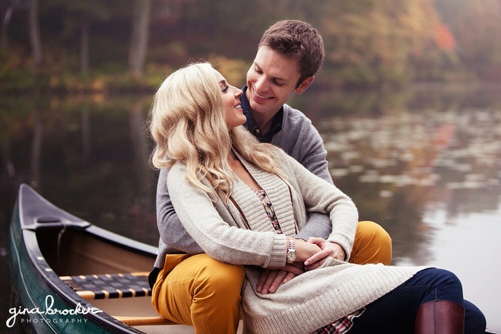 couple cuddle in a canoe during their couple session on the charles river in boston