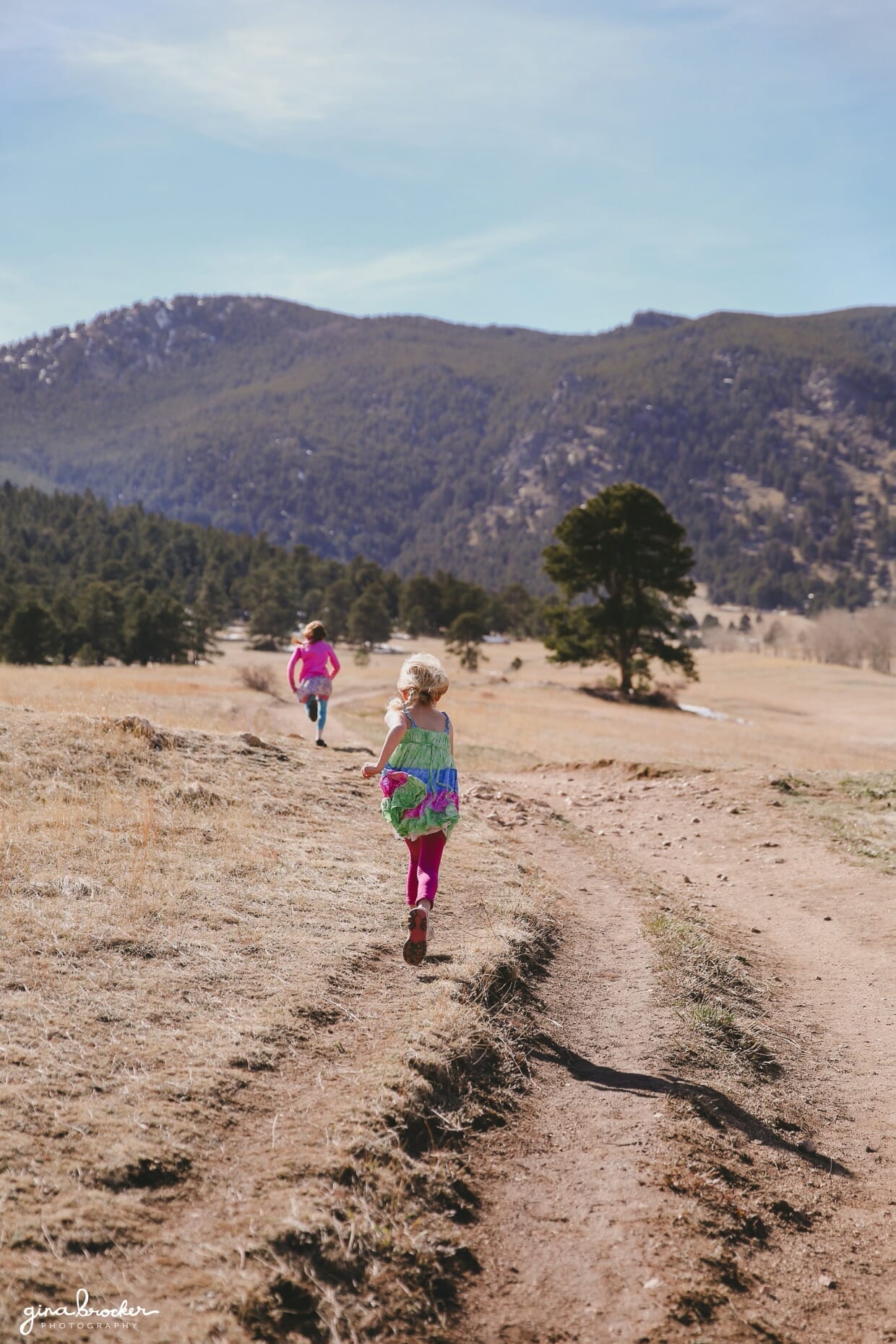 02.kids.running.outside Two sisters run towards the mountains during their outdoor family photography session