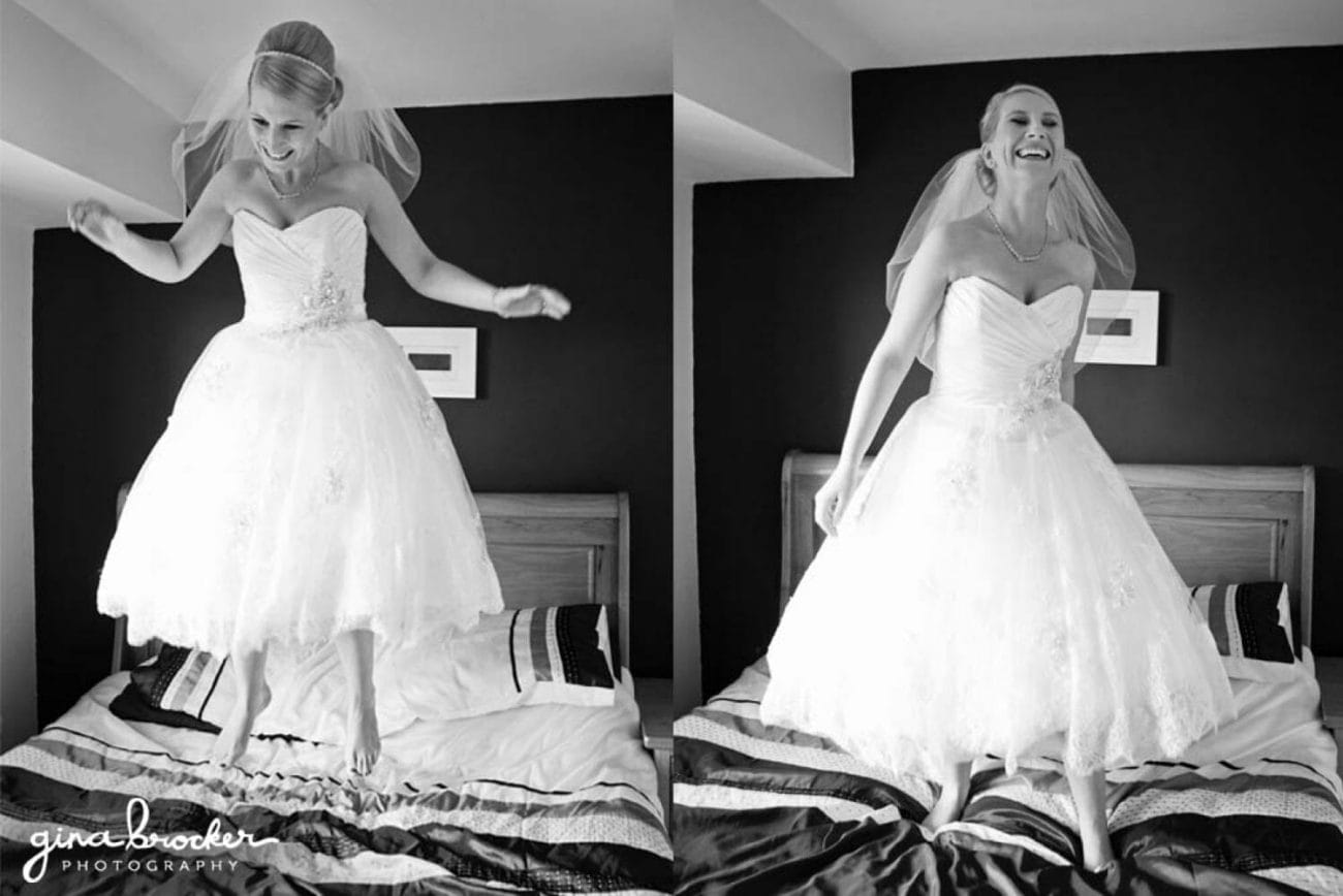 A bride wearing a retro style tea length dress jumps on her bed with excitement before her wedding