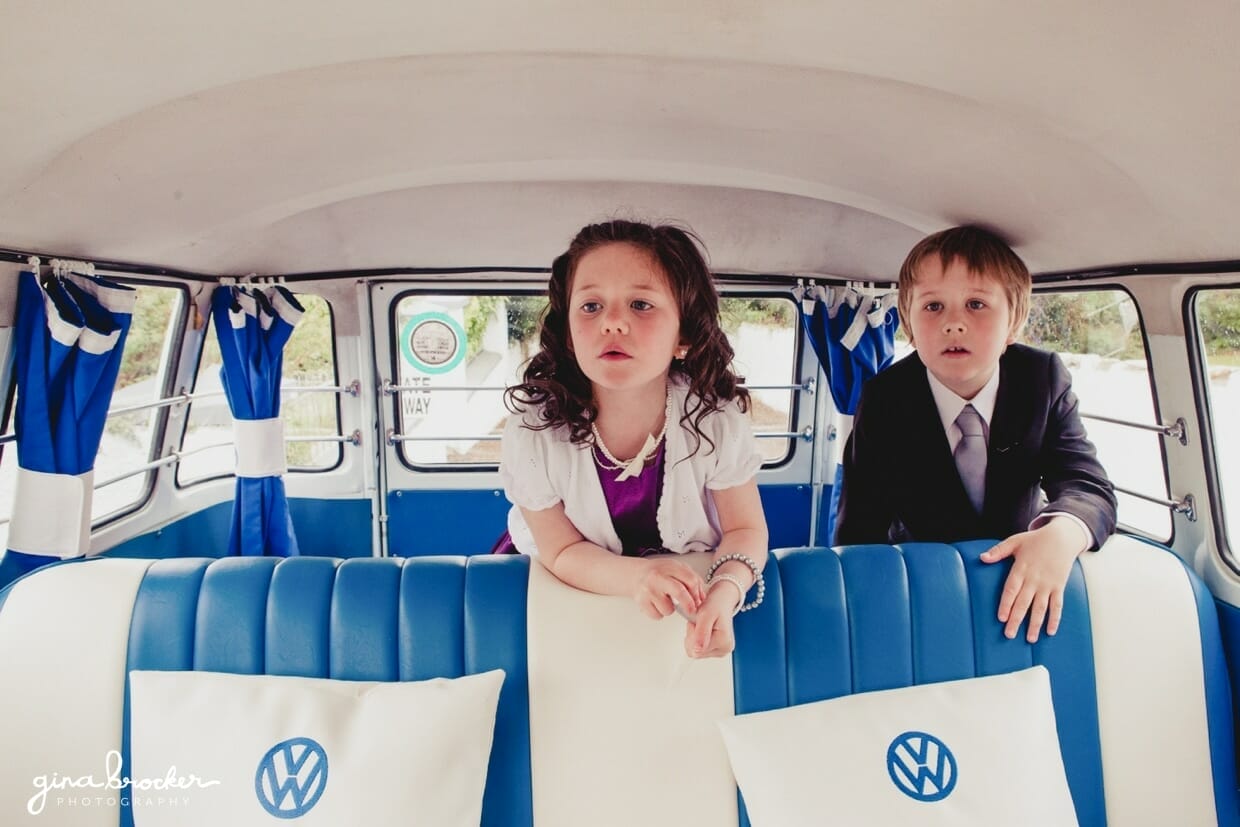 08.flower.girl.in.vw.bus A flower girl and ring bearer wait for the wedding party in a blue volkswagen bus on the morning of a retro wedding