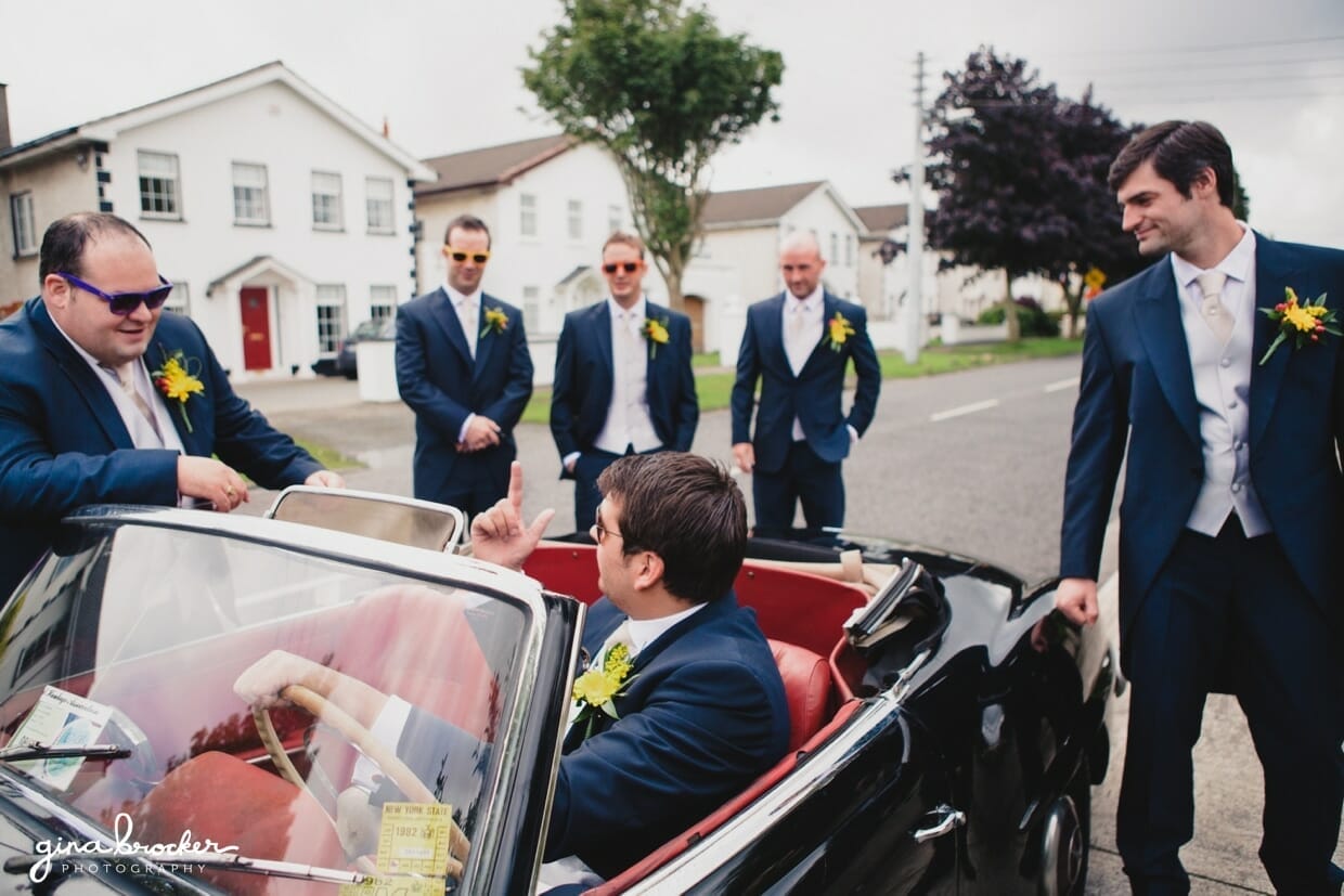 A candid photograph of groomsmen with a vintage mercedes benz convertible on the morning of a colorful and elegant wedding