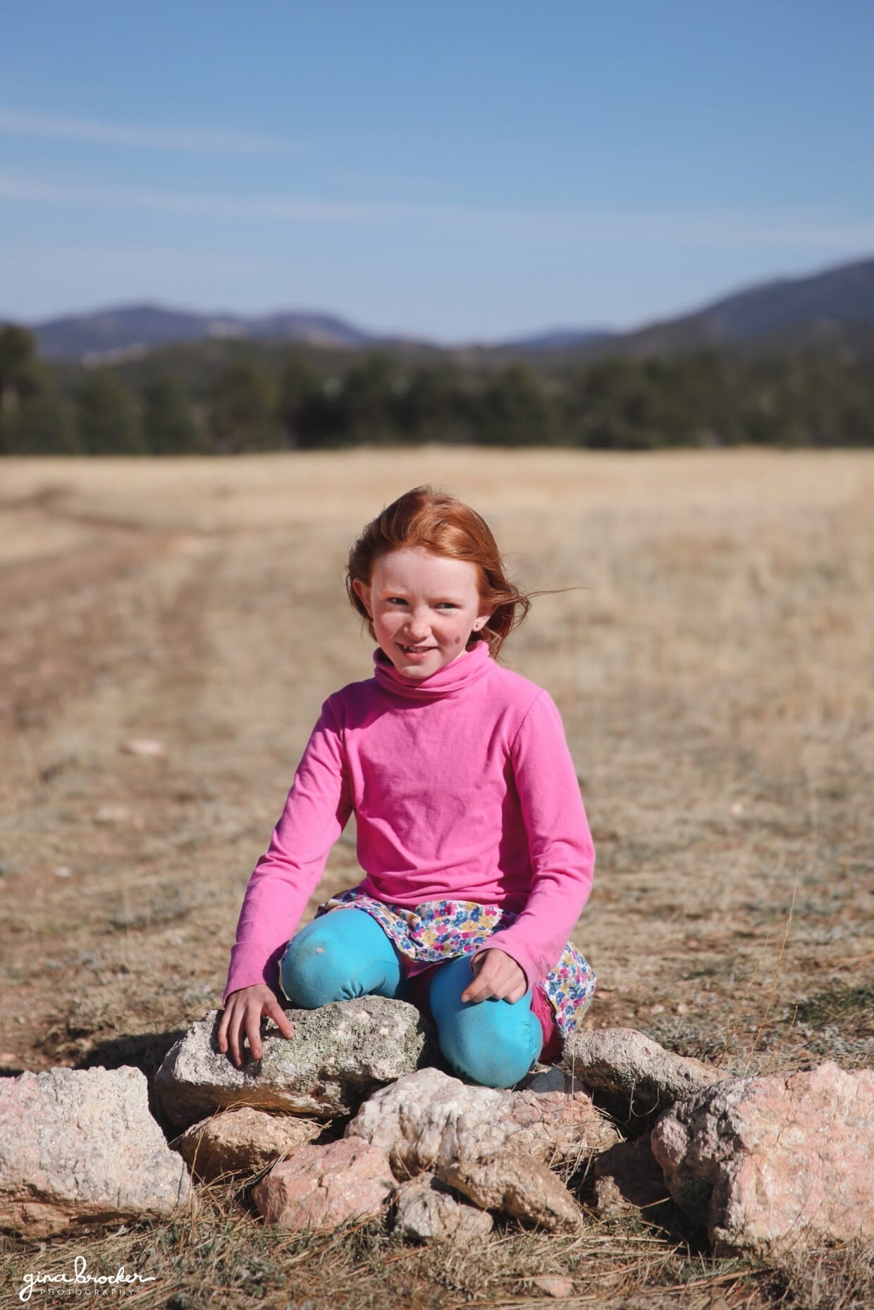 11.girl.sitting.on.rock.outside portrait of a young girl sitting on a rock in a field