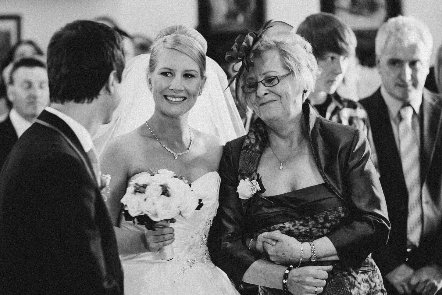 14.groom.meets.bride.during.ceremony The bride smiles at her groom as the meet at the top of the aisle during their church wedding ceremony