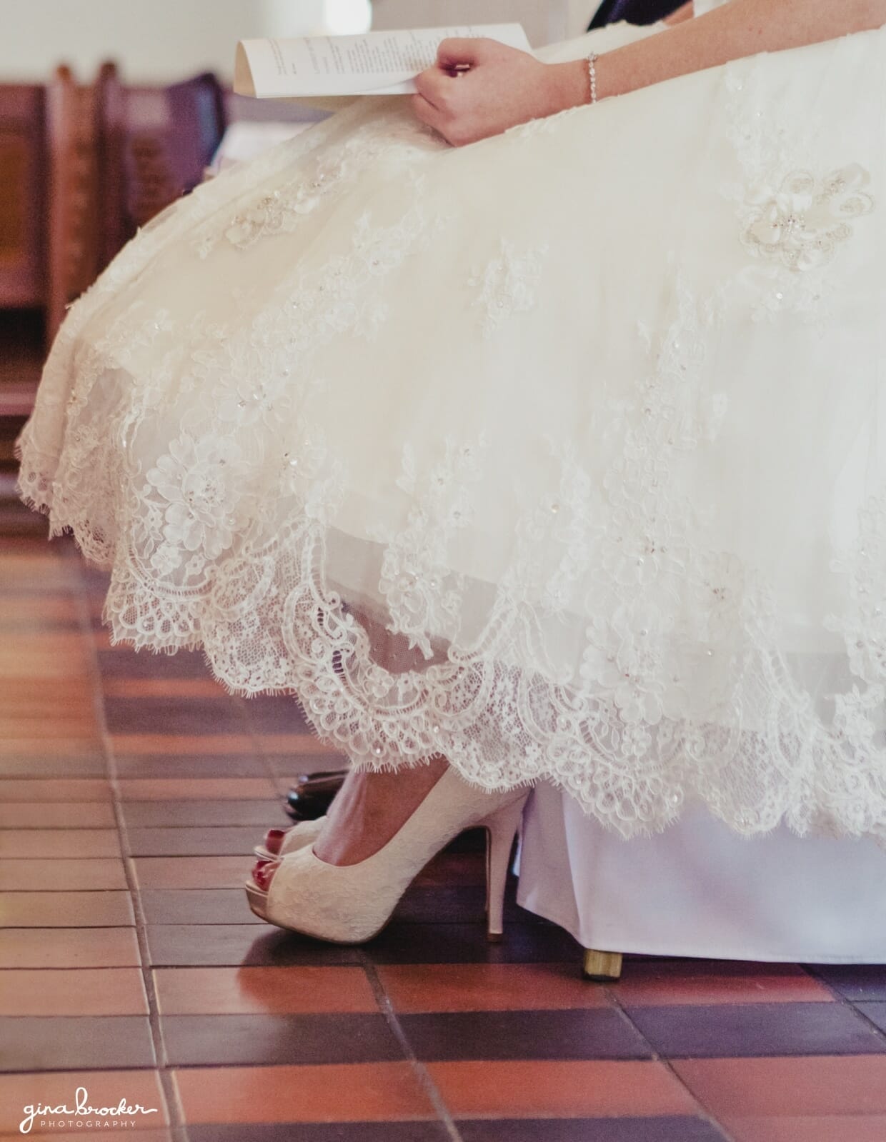 A detail of the brides lace tea length vintage inspired wedding dress during her church ceremony