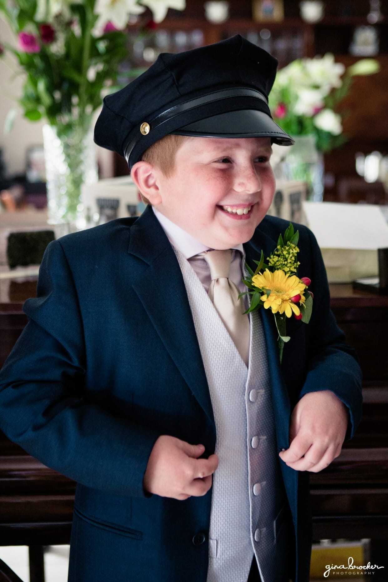 The ring bearer laughs as he wears the drivers hat on the morning of the wedding