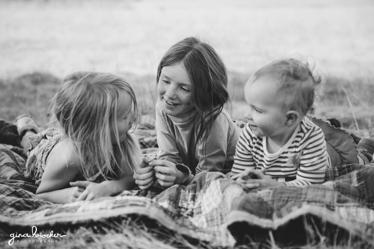 24.girls.talking Three young girls lay on a blanket outside and talk during their natural family photo session