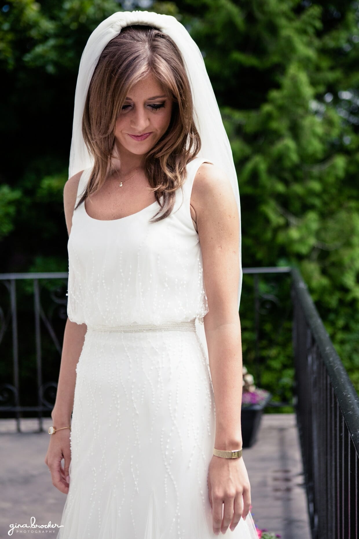 A natural portrait of a bride wearing a simple and elegant dress before she leaves for her wedding ceremony