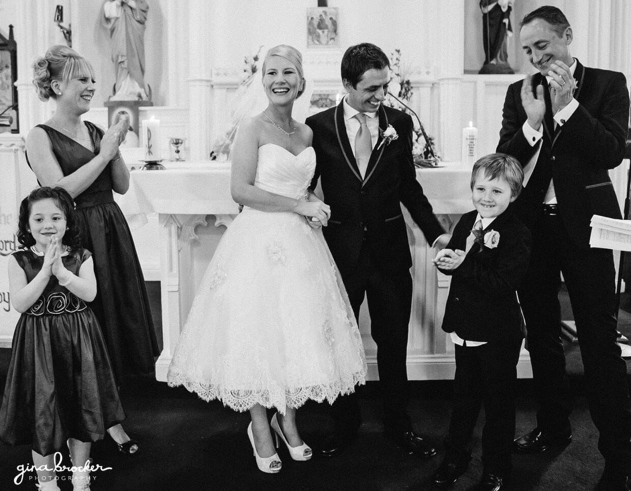 25.guest.clap.during.wedding.ceremony The wedding party claps as the bride and groom are pronounced husband and wife