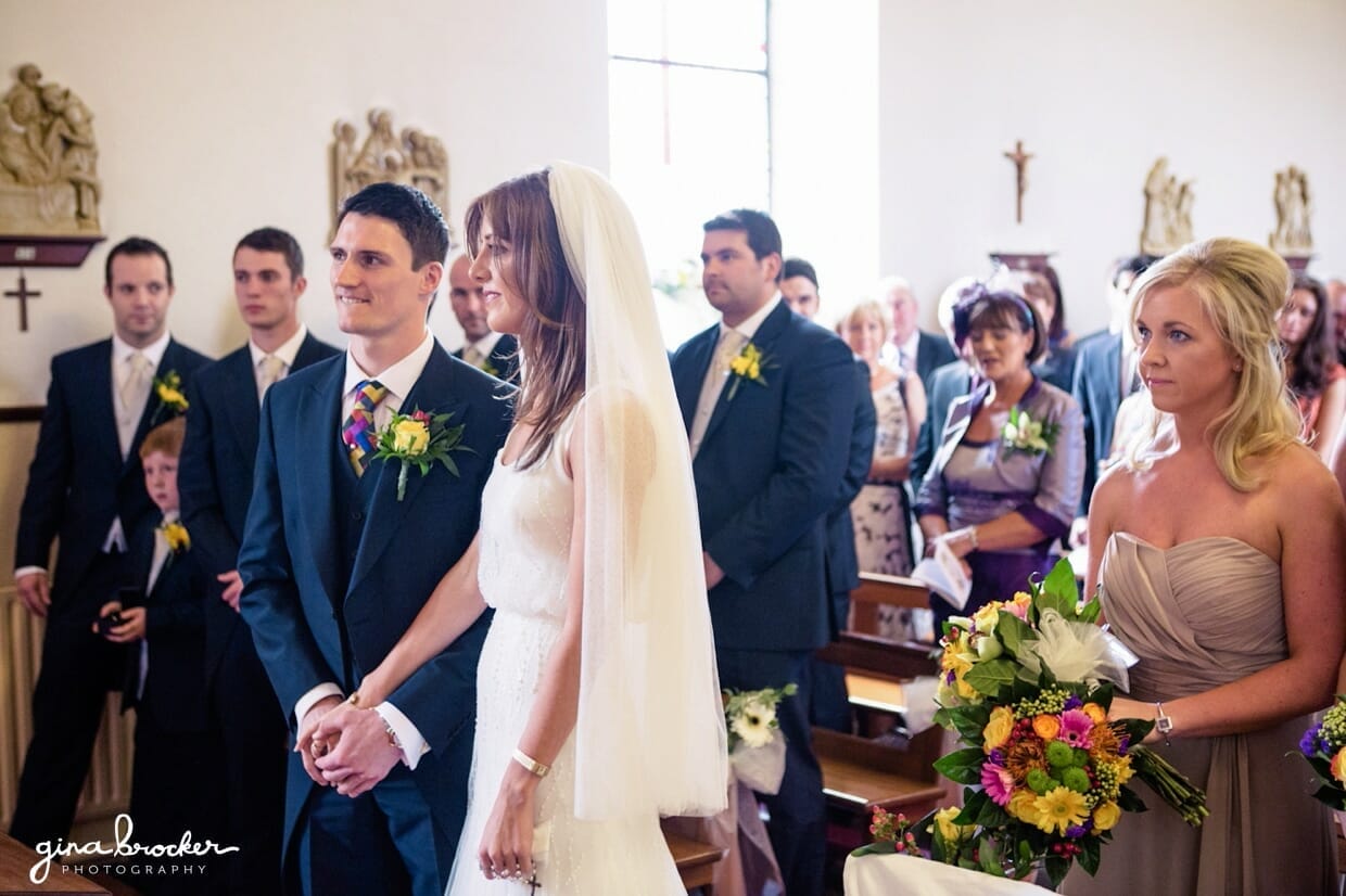 The bride and groom hold hands during their intimate religious wedding ceremony