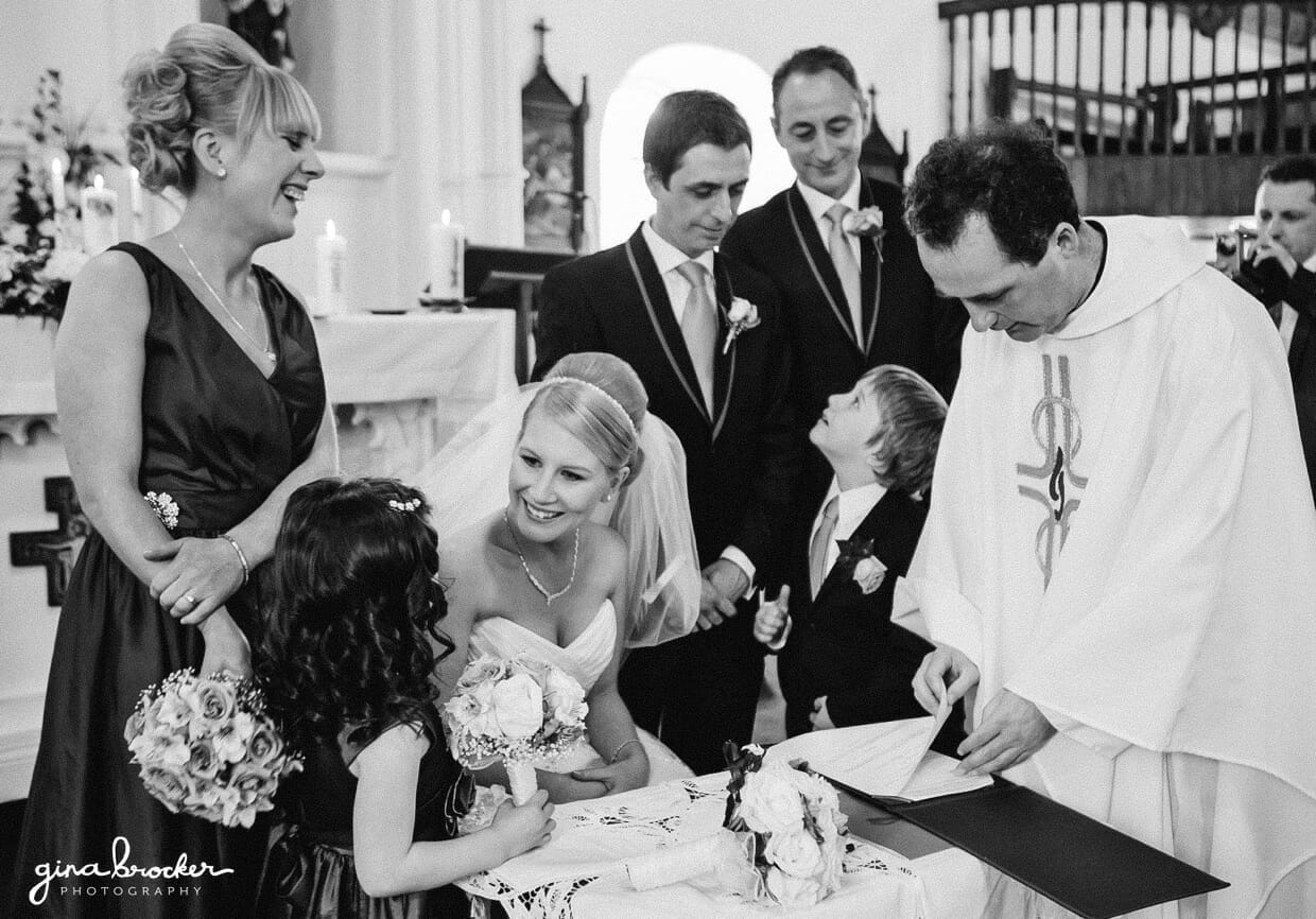 The wedding party congratulate the bride and groom as they sign their marriage papers