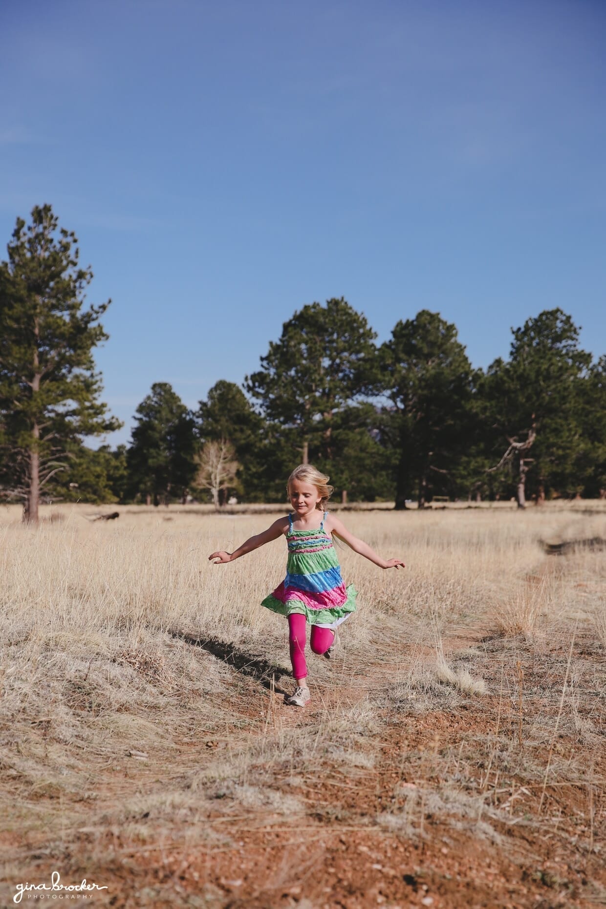 37.girl.running.in.field A little girl runs through a field during an outdoor family photo session