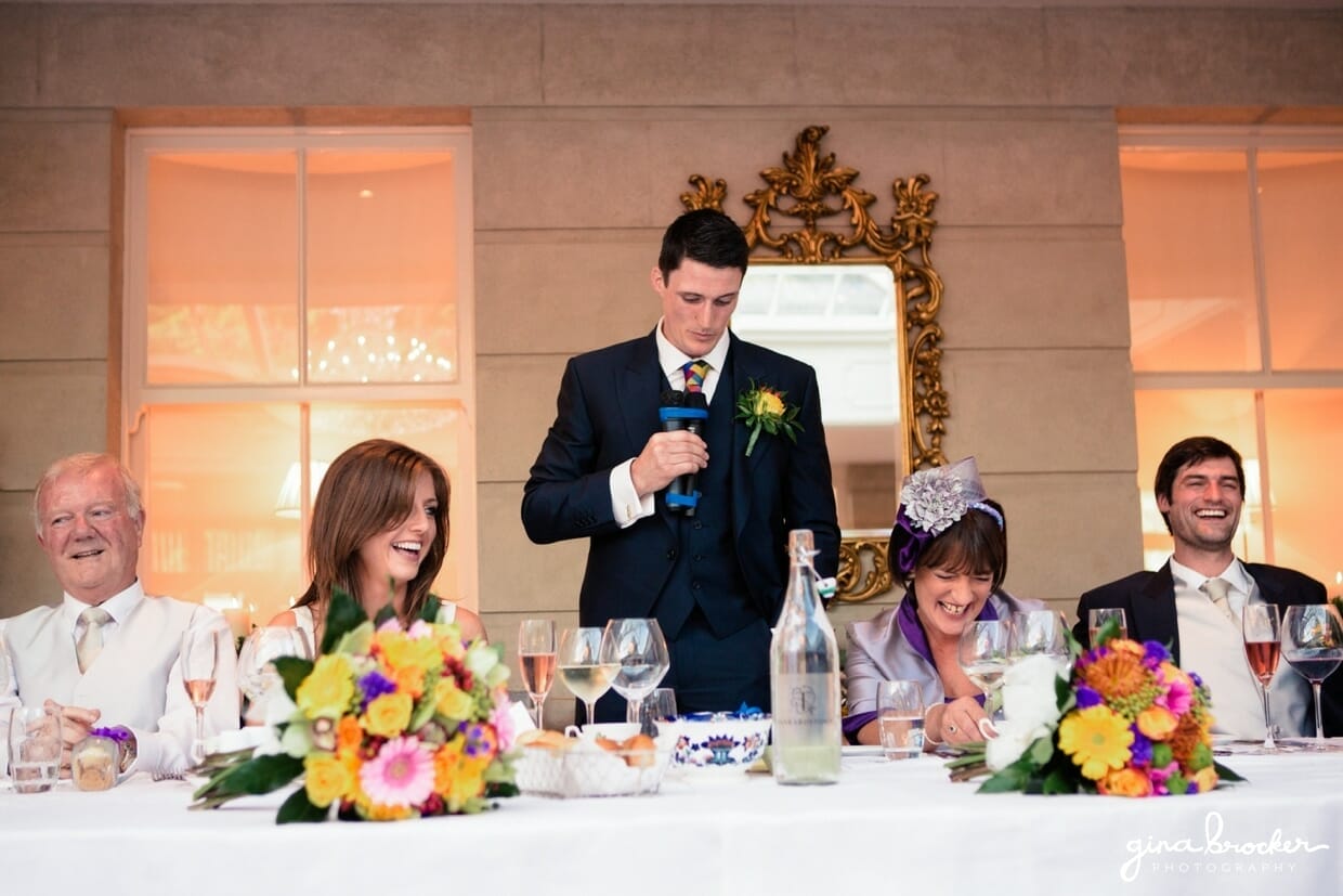The wedding party laugh as the groom gives his wedding speech