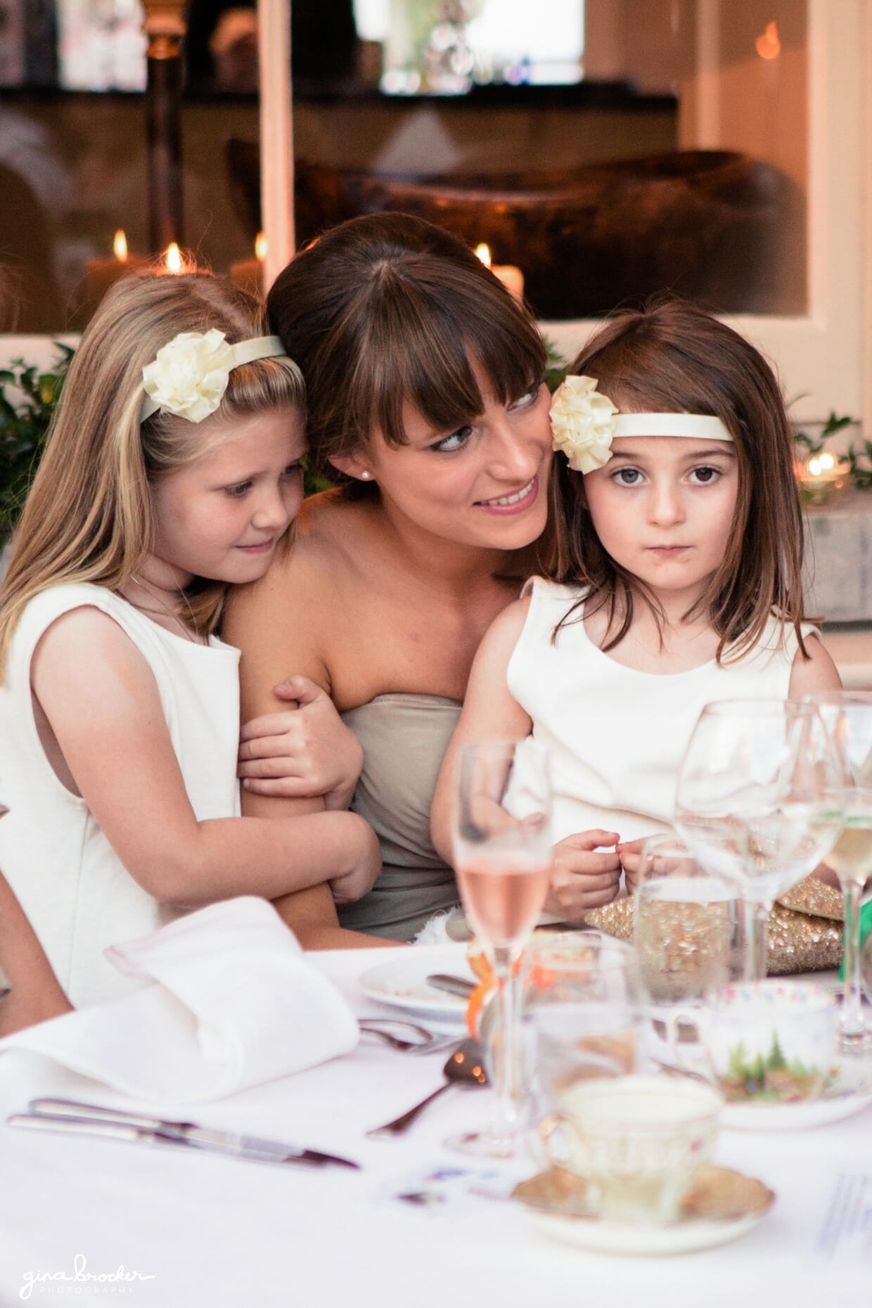 The flower girls sit on a bridesmaid lap during the wedding speeches