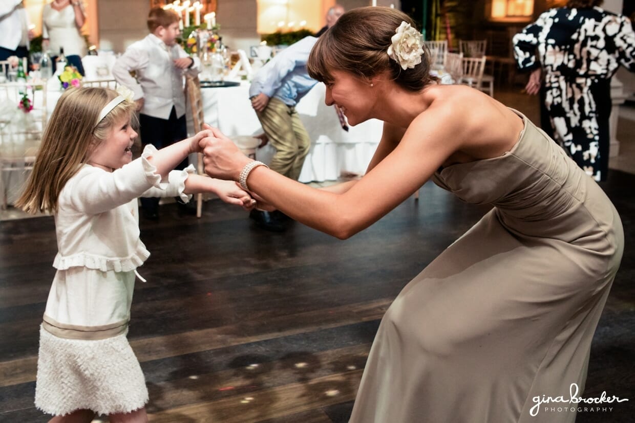 The bridesmaid dances with the flower girl at the colorful and elegant wedding
