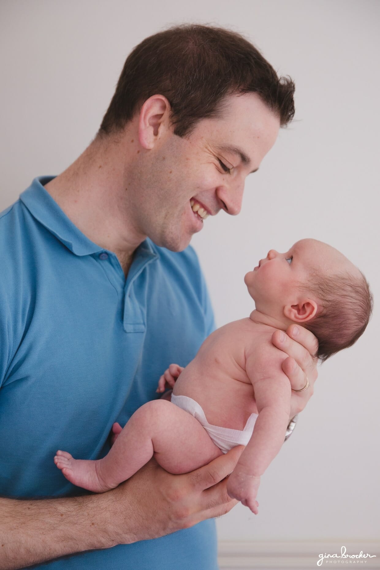 Dad holding baby during a family photo session in their Boston home.