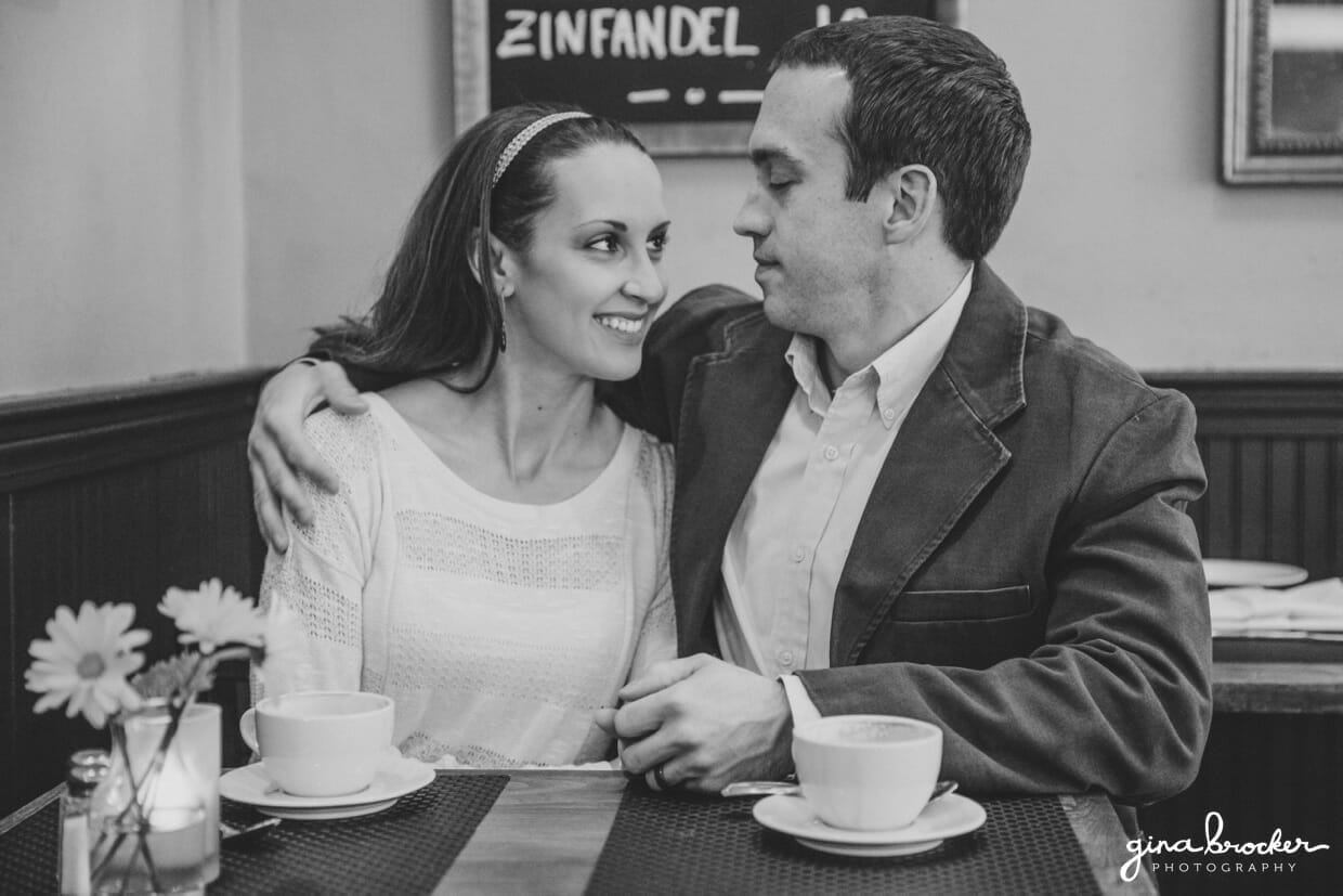 A husband wraps his arm around his wife during their sweet and natural beacon hill couple session in a boston cafe