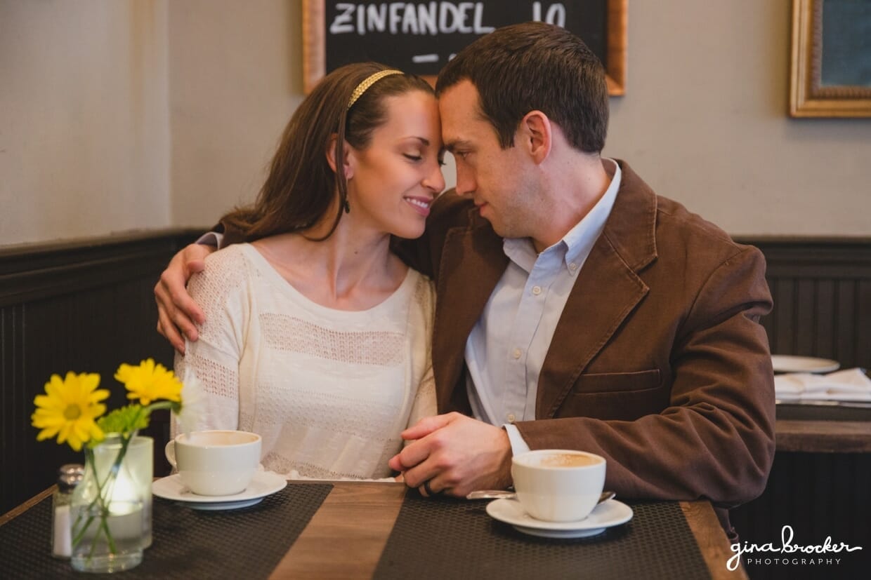 A couple cuddle at a cafe table during their relaxed and sweet beacon hill couple session at Panicificio
