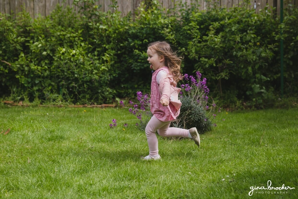 A little girl runs in her yard during a family photo session at home in Boston