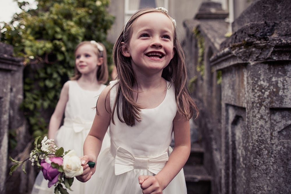A documentary style photograph of flower girls playing at a Boston Wedding