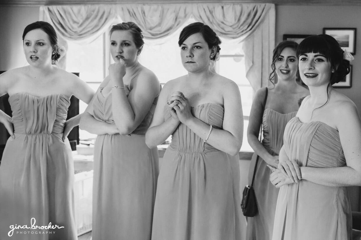 The bridesmaids look on in awe as the bride puts her final touches together before her wedding in Salem, Massachusetts