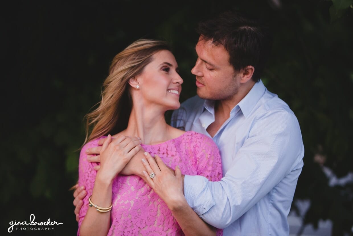 A sweet portrait of a couple as a woman in pink dress looks back at her fiancee during their prospect park engagement session in brooklyn, new york