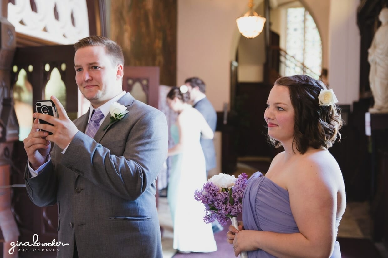 A groomsmen takes a photograph of the bride just before her wedding ceremony at the Sacred Heart of Jesus Church in Cambridge, Massachusetts