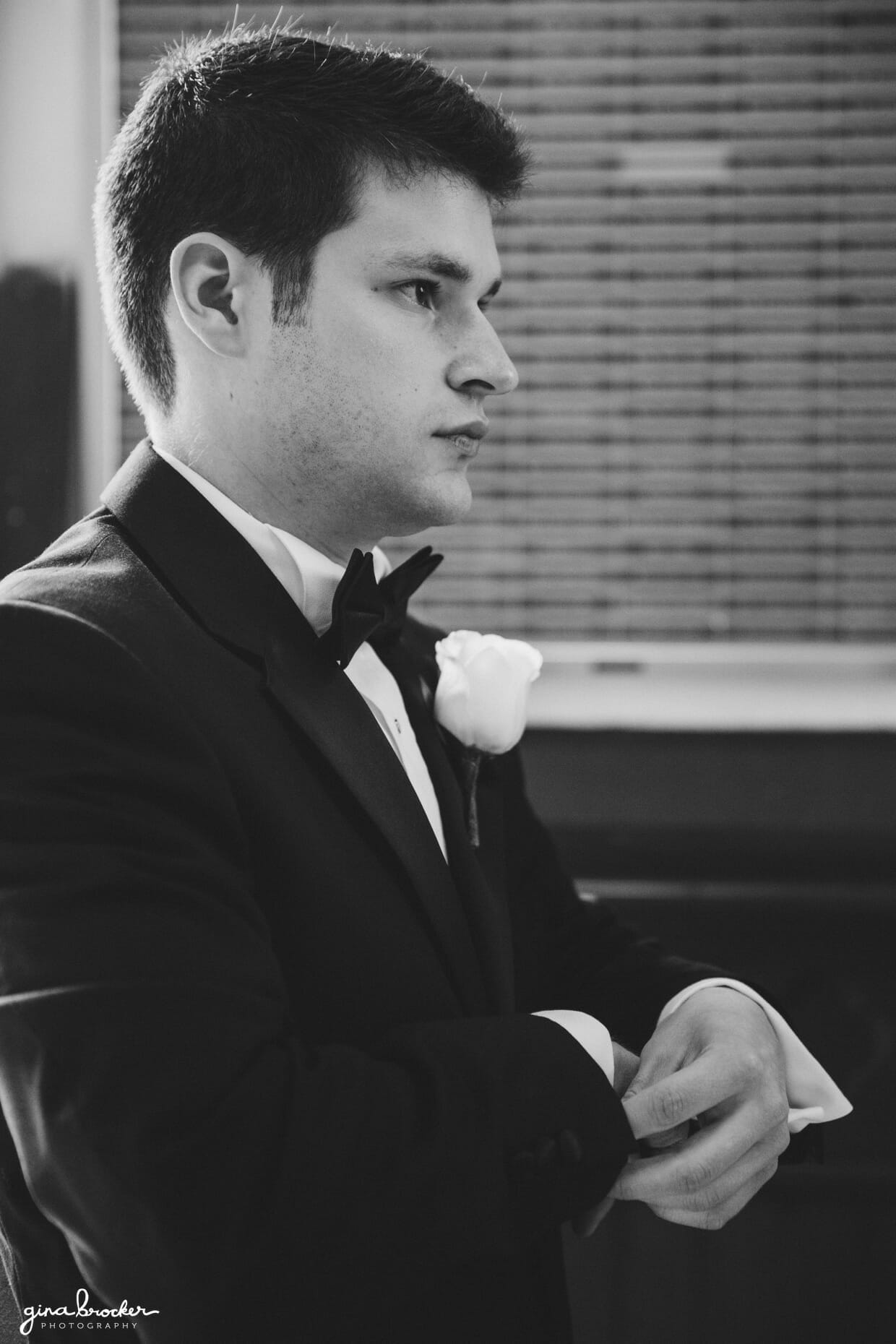 A groom adjust his cuffs while he waits for his bride to arrive to the Sacred Heart of Jesus Church in Cambridge, Massachusetts for their wedding ceremony.