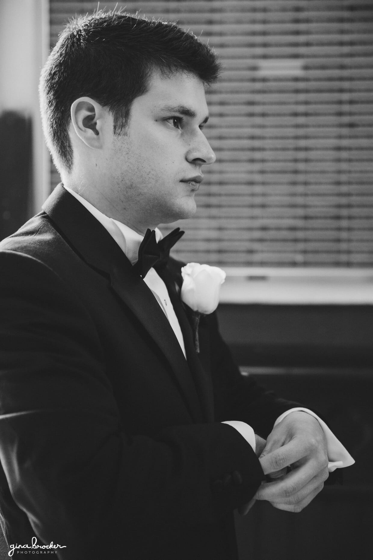 A portrait of groom fixing his cufflinks before his wedding ceremony in Salem, Massachusetts