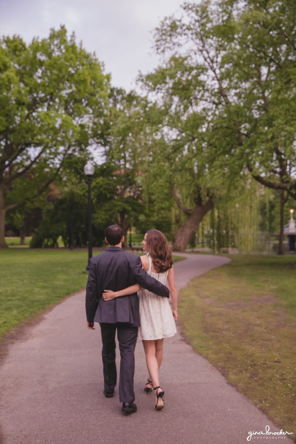 A couple walk together through the Boston Public Gardens during their sweet springtime engagement session