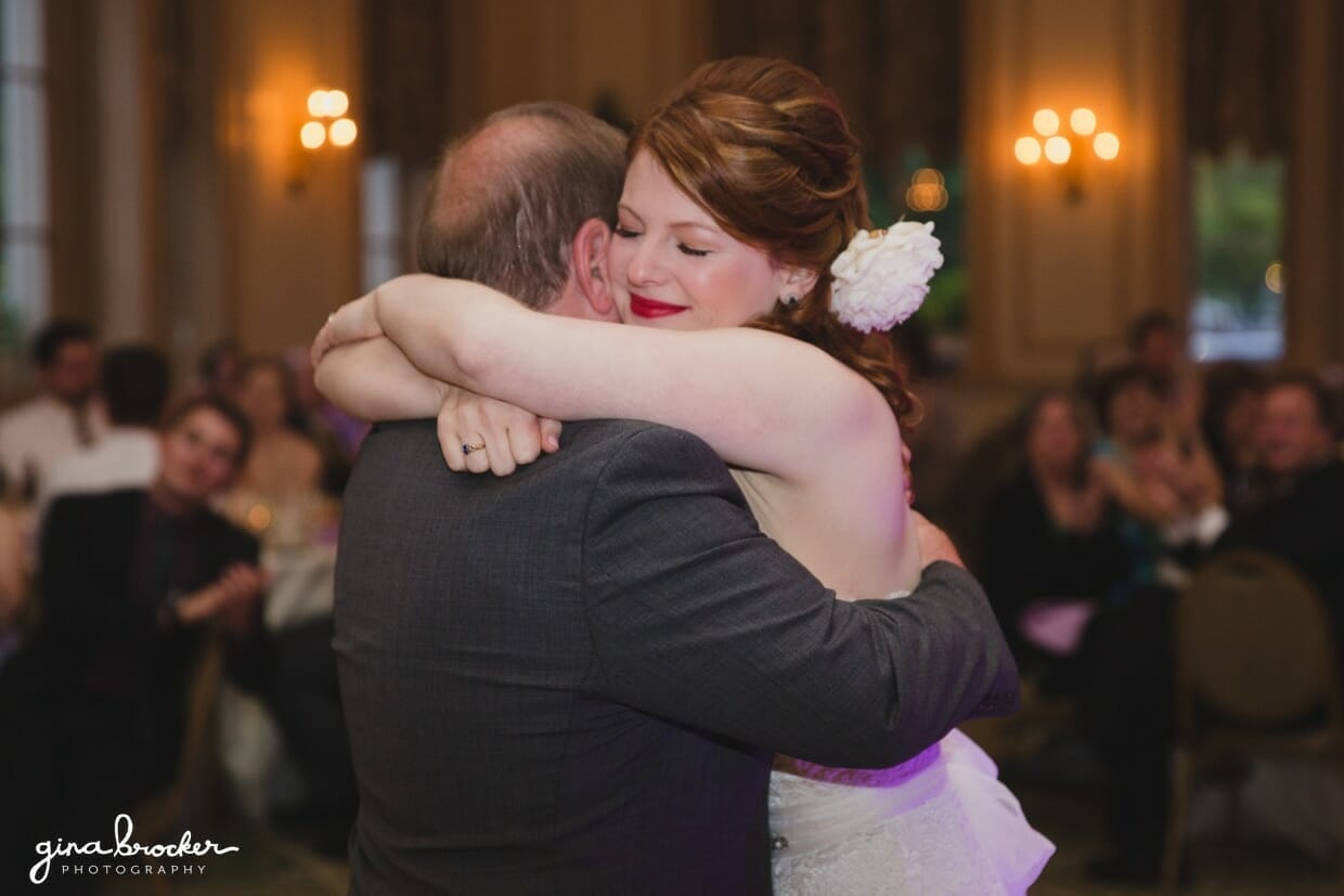 A bride hugs her father after their father daughter dance in the Hawthorne Hotel in Salem, Massachusetts