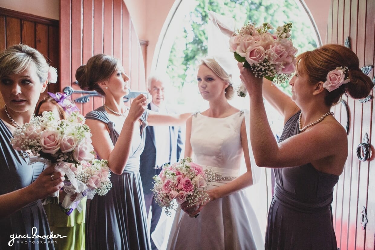 A candid photograph of the bride and bridesmaids just before they walk up the aisle for the church wedding ceremony