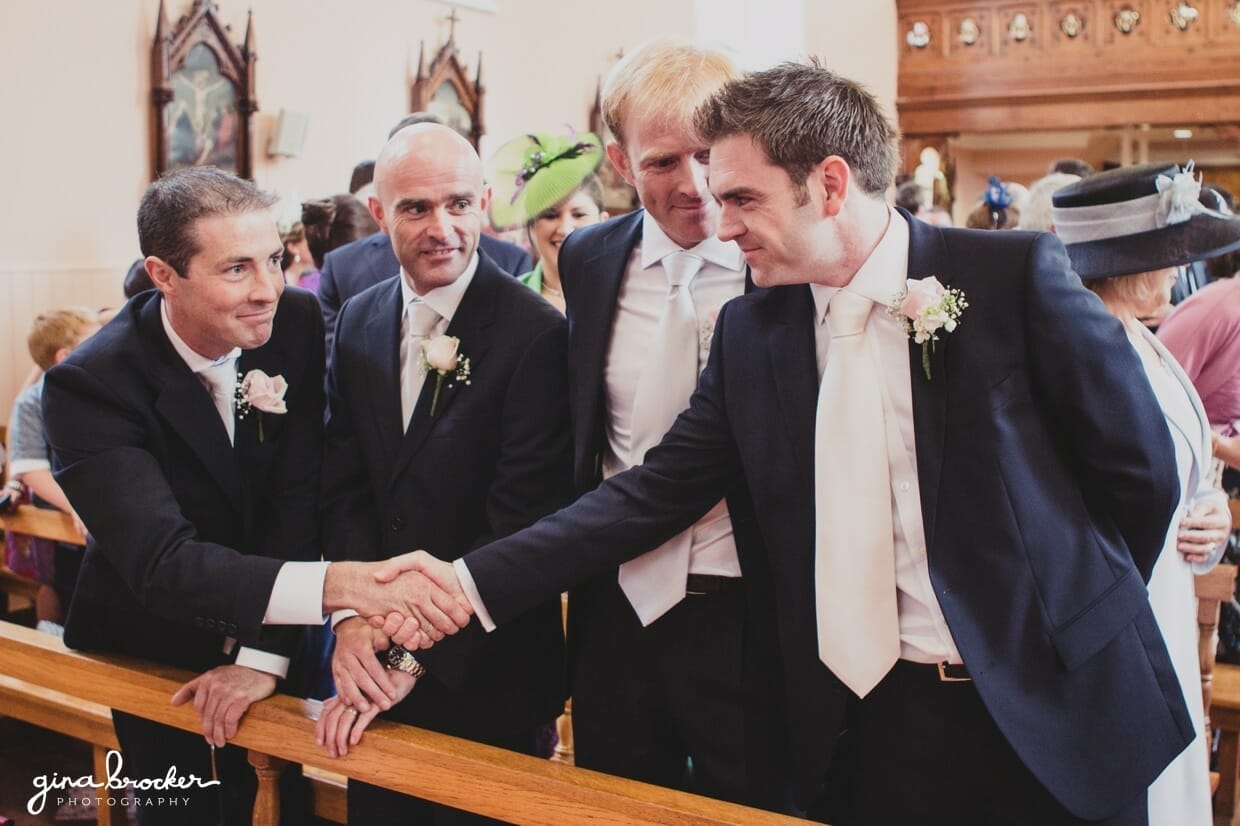 The groomsmen congratulate the groom by shaking his hand during his wedding ceremony in Boston, Massachusetts