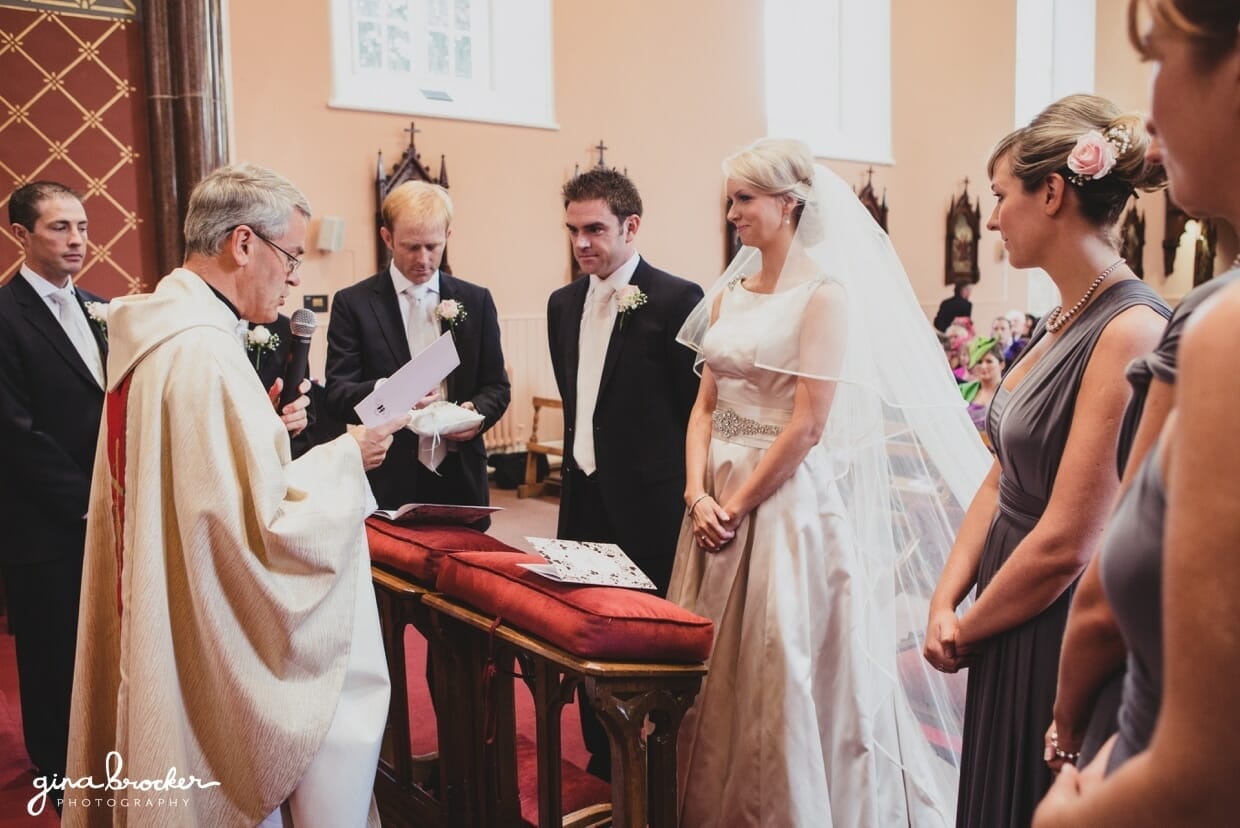 The bride and groom join the priest and their wedding party at the top of alter for their wedding vows