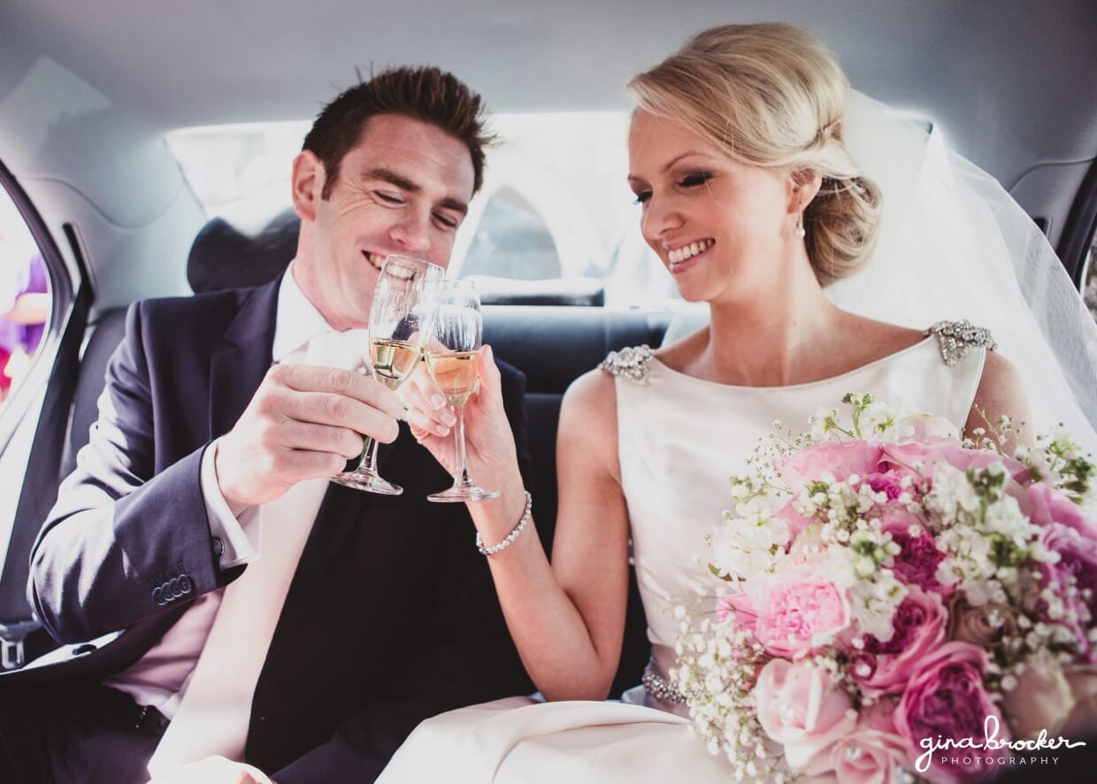 The bride and groom share a champagne toast as they drive to the wedding reception in their wedding car
